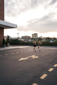 dwie kobiety biegnące po ulicy w mieście lecząc kontuzje