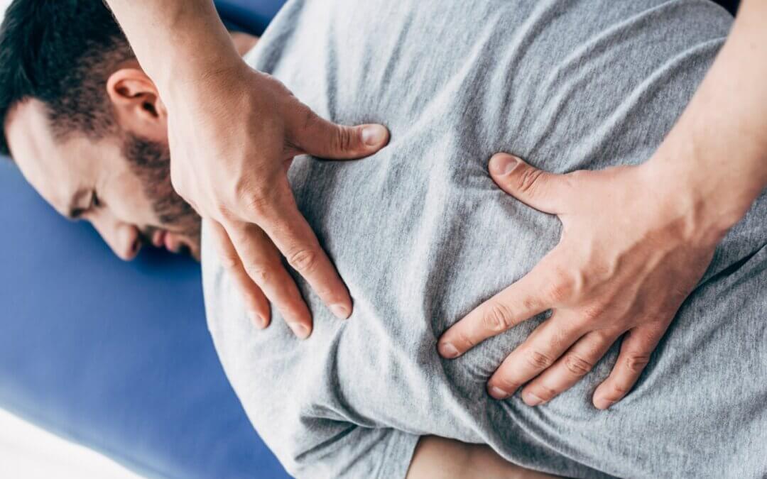 ból kręgosłupa mężczyzny leżącego na leżance poddającego się fizjoterapii